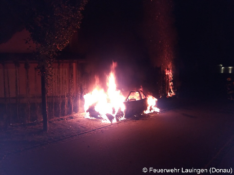 Brennender Pkw und brennende Hecke